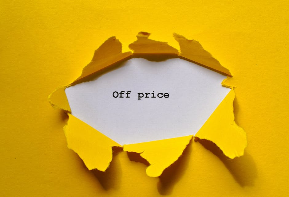 A piece of bright yellow paper is torn open to reveal a white card inside with the words 'Off price' printed in black ink. The torn edges of the yellow paper are rough and uneven, creating a jagged bo